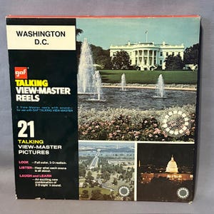 May include: A vintage View-Master reel set featuring Washington D.C. scenes. The box displays images of the White House, fountains, and other landmarks. The set includes 21 talking view-master pictures. The box is black, white, and red.
