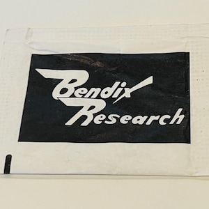 May include: A white paper packet with black text that reads "Bendix Research".