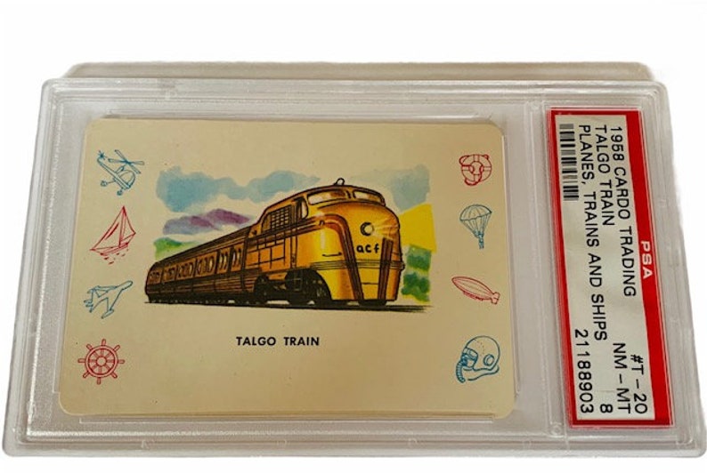 Puede incluir: Una tarjeta de colecci&oacute;n vintage que presenta un tren Talgo amarillo y marr&oacute;n con el texto "TALGO TRAIN" y "acf" en el lateral. La tarjeta est&aacute; rodeada de peque&ntilde;as ilustraciones de varios modos de transporte, incluyendo un velero, un helic&oacute;ptero, un paraca&iacute;das y un dirigible. La tarjeta est&aacute; calificada por PSA y tiene una calificaci&oacute;n de NM-MT 8.