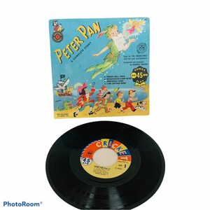 May include: A vintage Peter Pan record album and vinyl record. The album cover is light blue with illustrations of Peter Pan, Captain Hook, and other characters. The record is black with a colorful label.
