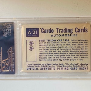 May include: A vintage trading card featuring a yellow taxi cab. The card is from the Cardo Trading Cards series, number A-21, and is titled "First Yellow Cab 1908". The card describes the history of the yellow taxi cab in the United States.
