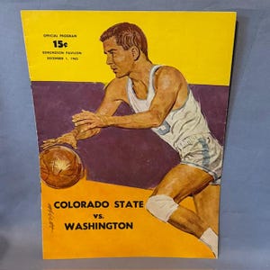 Pode incluir: Capa de programa de basquete vintage com um jogador em uniforme branco e azul driblando uma bola de basquete marrom. O programa é para o jogo Colorado State vs. Washington, 1º de dezembro de 1962. A capa tem um fundo amarelo e roxo.