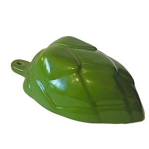 Puede incluir: Un objeto brillante verde en forma de hoja con un pequeño agujero en un extremo. El objeto tiene una superficie lisa y reflectante y parece estar hecho de un material sólido. El diseño se asemeja a una hoja estilizada.