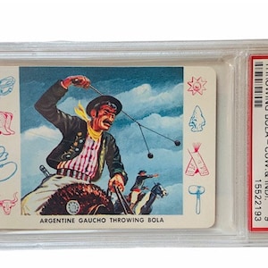 Puede incluir: Una tarjeta de colecci&oacute;n vintage que presenta una ilustraci&oacute;n colorida de un gaucho argentino a caballo lanzando una bola. La tarjeta es de la serie Carco Trading de 1958 y est&aacute; calificada como en perfecto estado por PSA. La tarjeta presenta el texto "Argentine Gaucho Throwing Bola" y "#C-6 Mint 6 15522193".