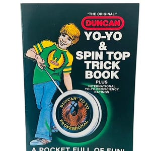 May include: A green booklet featuring a boy on the cover holding a yo-yo. The booklet is titled "The Original! Duncan Yo-Yo & Spin Top Trick Book" with the text "Plus International Yo-Yo Proficiency Ratings" and "A Pocket Full of Fun!"