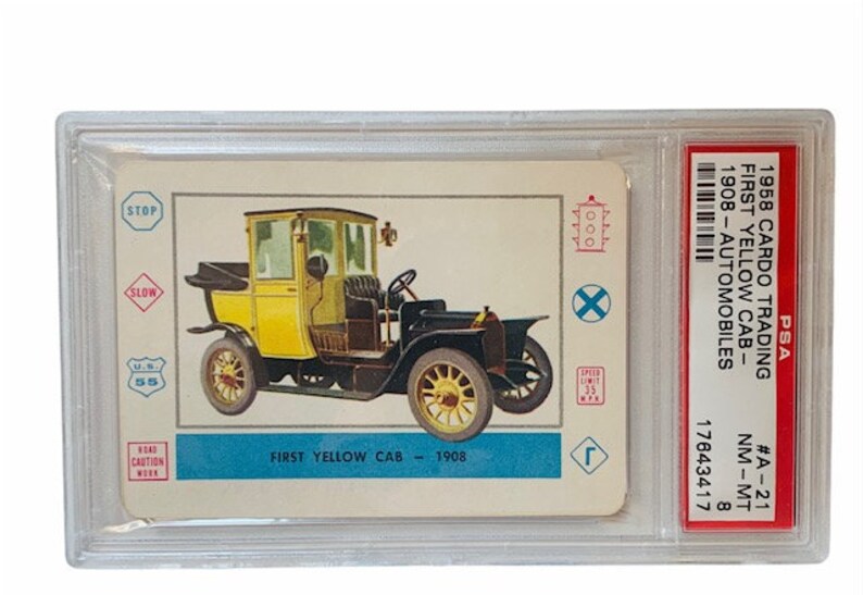 May include: A PSA graded card featuring a yellow 1908 First Yellow Cab automobile. The card is in near mint condition and has a grade of 8. The card is from the 1958 Car-Do Trading Automobiles series.
