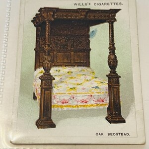 May include: A vintage illustration of an ornate oak bedstead with a canopy and a floral patterned bedspread. The image is from a Wills's Cigarettes card and includes the text "WILLS'S CIGARETTES" and "OAK BEDSTEAD."