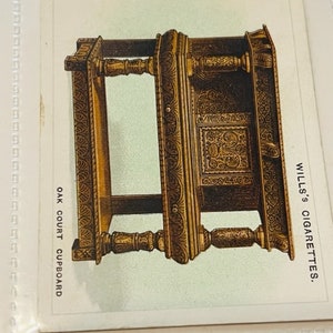 May include: A detailed illustration of an ornately carved oak court cupboard with intricate details. The image is from a vintage Wills's Cigarettes card.