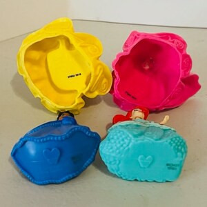 May include: Four plastic princess dolls with removable skirts. The dolls are Ariel, Belle, Cinderella, and Snow White. The skirts are yellow, pink, blue, and turquoise.