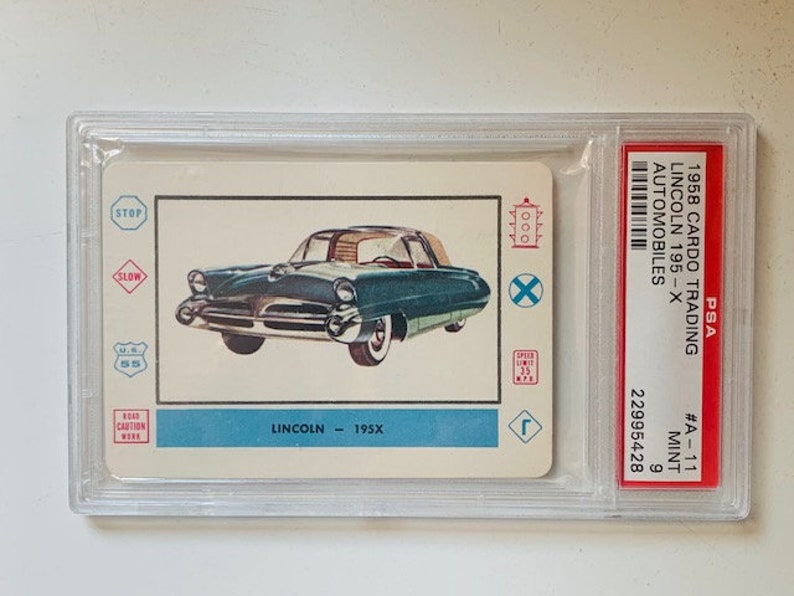 Puede incluir: Una tarjeta de colecci&oacute;n vintage CarDo Trading de 1958 con un autom&oacute;vil Lincoln 195X azul. La tarjeta tiene un esquema de color rojo, blanco y azul e incluye varias se&ntilde;ales de tr&aacute;fico.