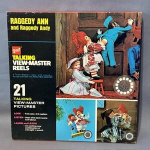 May include: A vintage GAF Talking View-Master Reels box featuring Raggedy Ann and Raggedy Andy. The box is black and brown, with 3D images of the characters. The box includes the text "21 Talking View-Master Pictures".