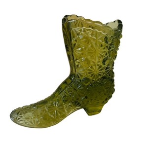 May include: A green glass boot-shaped vase with a diamond pattern.