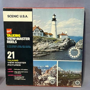 May include: A vintage View-Master reel set titled "Scenic U.S.A." featuring 21 talking 3-D pictures. The box displays images of a lighthouse, mountains, and a city skyline. The box is rectangular and has the GAF logo.