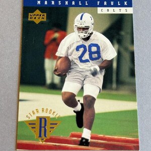 May include: A football trading card featuring Marshall Faulk of the Colts. The card shows Faulk in a white jersey with the number 28, running with a football. The Upper Deck logo and "Star Rookie" text are visible.