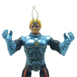 May include: A blue and silver action figure with a yellow head and blue eyes. The figure has a silver chest plate with a gold star in the center. The figure is wearing a blue and silver helmet with a silver antenna.