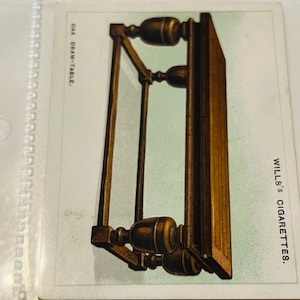 May include: A vintage illustration of an oak draw-table with intricate details. The table has a rectangular top and four legs with decorative carvings. The image is from a Wills's Cigarettes card.