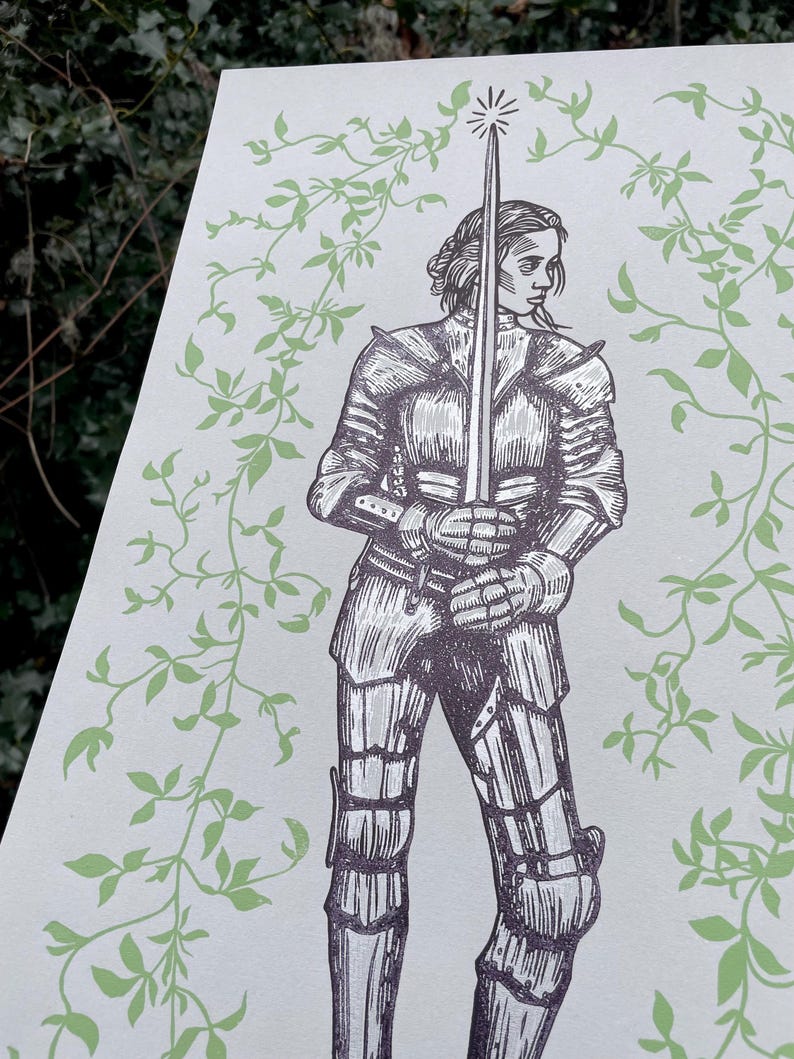 May include: A black and white illustration of a woman in armour holding a sword. The background is a light green with a vine pattern.