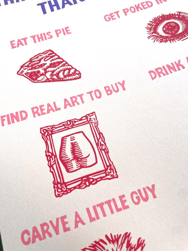 May include: A white paper with red and purple text and illustrations. The text includes phrases like "Eat This Pie" and "Find Real Art to Buy." Illustrations include a pie slice, an eye, and a framed image of a butt.