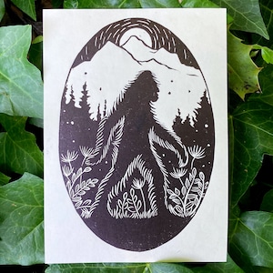 Può includere: Stampa a linoleum in bianco e nero di un Bigfoot che cammina attraverso una foresta con la luna piena sullo sfondo.