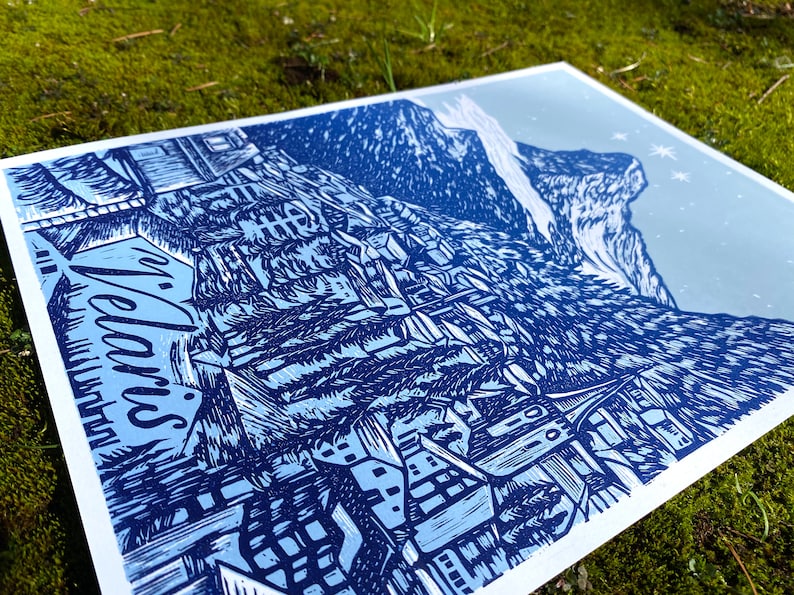 May include: A blue and white linocut print depicting a mountain village with the word "Welcome" in a stylised font.