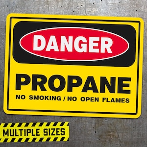 May include: Yellow and black warning sign with the words "DANGER PROPANE NO SMOKING / NO OPEN FLAMES" in black text. A red oval with the word "DANGER" in white text is at the top of the sign.