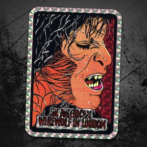 May include: A holographic sticker featuring a werewolf with a red and orange background. The sticker has the text "An American Werewolf in London" in a white box.