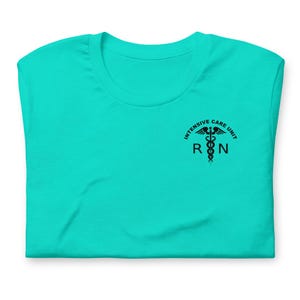 Folded turquoise ICU nurse shirt with black critical care RN left-chest graphic.