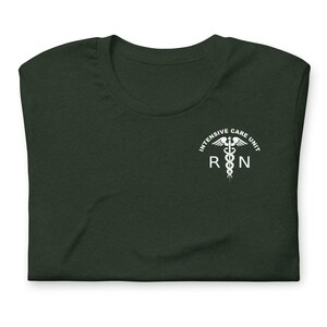 Folded forest green ICU nurse shirt with white critical care RN left-chest design.