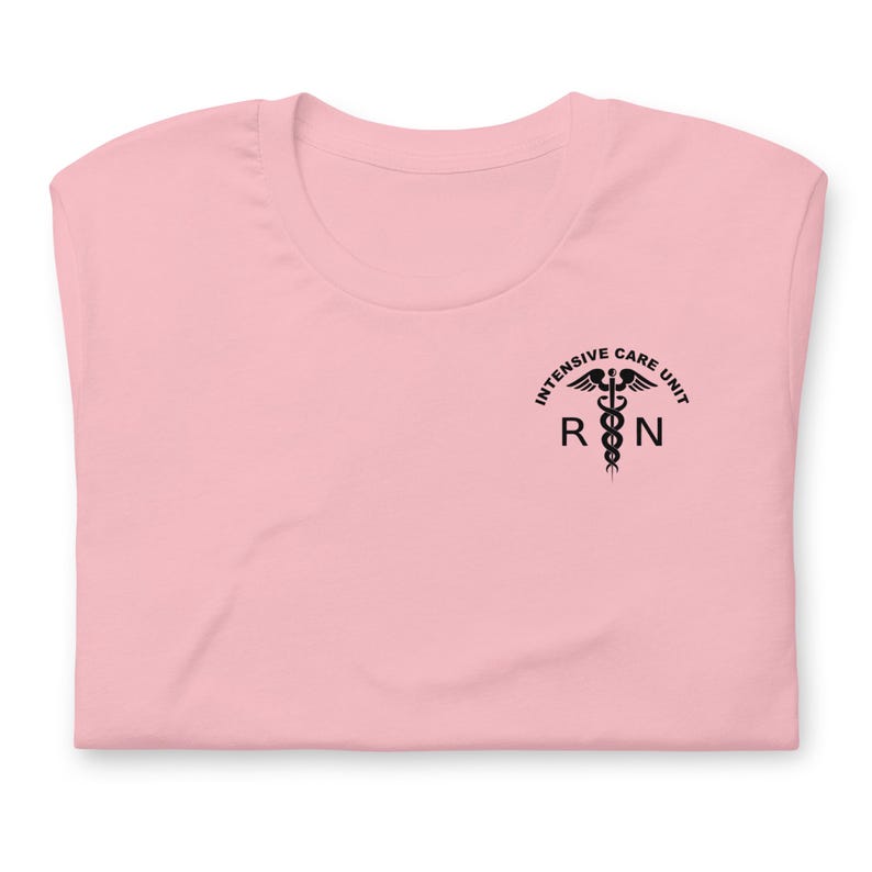 Folded light pink ICU nurse shirt with black Intensive Care Unit RN chest graphic.
