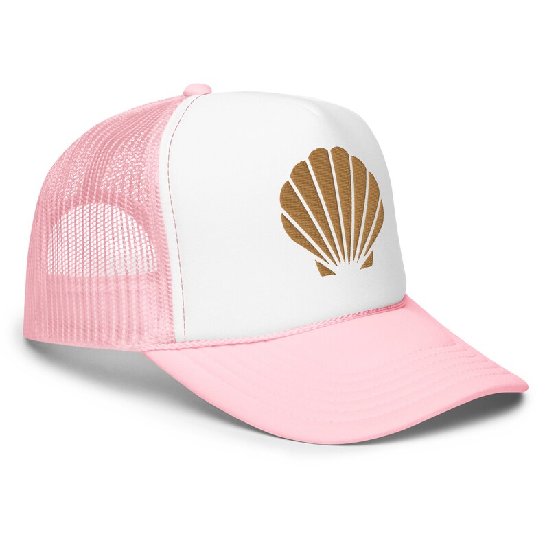 May include: A pink and white trucker hat with a brown seashell design on the front.