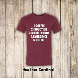 May include: A maroon t-shirt with white text that reads "1. Coffee 2. Induction 3. Maintenance 4. Emergence 5. Coffee". The shirt is made of a soft, comfortable material and is available in Heather Cardinal.