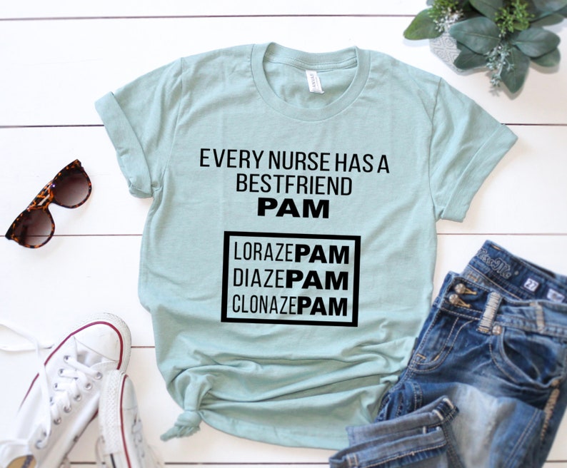May include: A light blue t-shirt with the text "Every nurse has a best friend PAM" and a box with the text "Lorazepam, Diazepam, Clonazepam" in black text.
