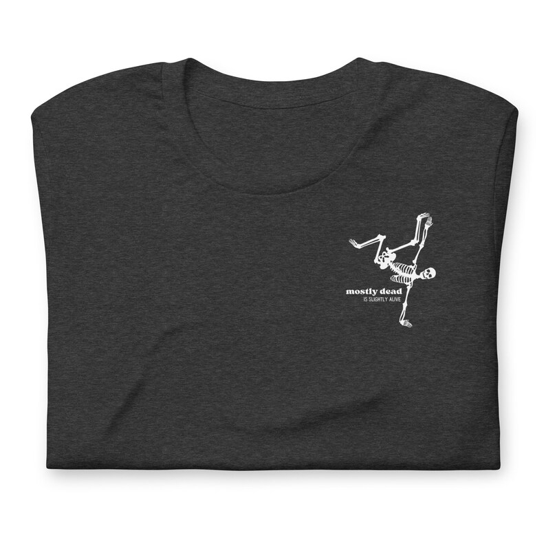 Puede incluir: Una camiseta gris oscuro jaspeada con un gr&aacute;fico de esqueleto blanco y el texto "mostly dead is slightly alive".