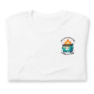 Puede incluir: Camiseta blanca con un contenedor de basura verde en llamas con una cara linda y el texto "This little light of mine I'm gonna let it shine."