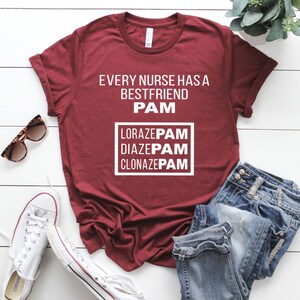 May include: A maroon t-shirt with the text "Every nurse has a best friend PAM" and a box with the text "LORAZEPAM DIAZEPAM CLONAZEPAM" in white.