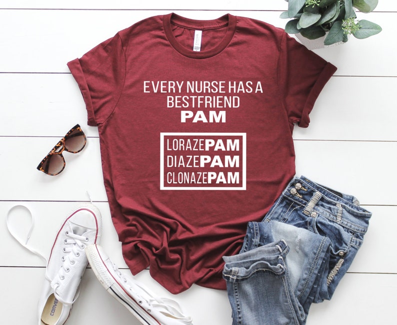 May include: A maroon t-shirt with the text "Every nurse has a best friend PAM" and a box with the text "LORAZEPAM DIAZEPAM CLONAZEPAM" in white.