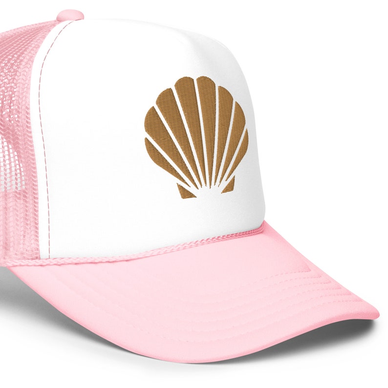 May include: A pink and white trucker hat with a brown seashell graphic on the front.