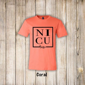May include: Coral colored t-shirt with black text that reads "NICU Nurse" in a square frame.