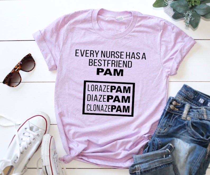 May include: A light purple t-shirt with the text "Every nurse has a best friend PAM" and a box with the text "LORAZEPAM DIAZEPAM CLONAZEPAM" in black.
