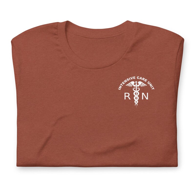 Folded rust-colored ICU nurse shirt with white critical care RN chest graphic.