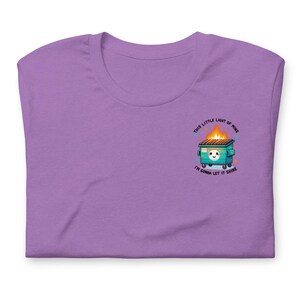 Puede incluir: Camiseta morada con un gr&aacute;fico de un contenedor verde en llamas con el texto "This little light of mine, I'm gonna let it shine."