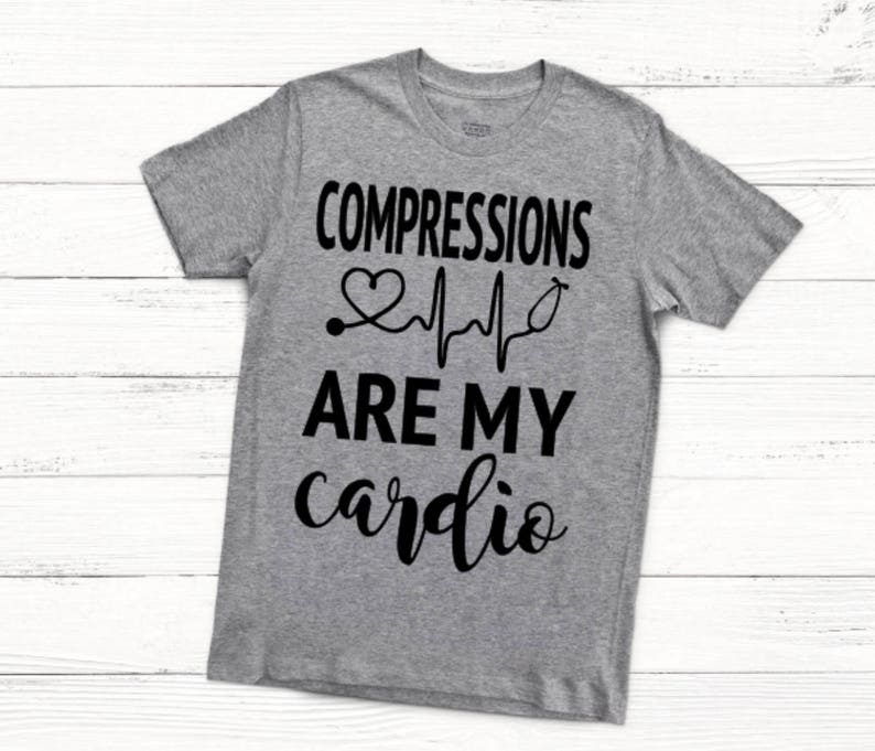 May include: Gray t-shirt with black text that reads "COMPRESSIONS ARE MY cardio" with a heart and EKG graphic.