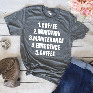 May include: Gray t-shirt with white text that reads "1. Coffee 2. Induction 3. Maintenance 4. Emergence 5. Coffee"