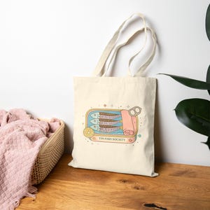 Coastal sardine tote bag with Mediterranean seafood aesthetic design on neutral interior background