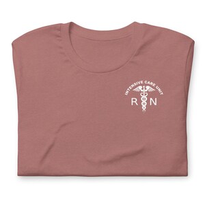 Folded mauve ICU nurse shirt with white Intensive Care Unit RN left-chest print.