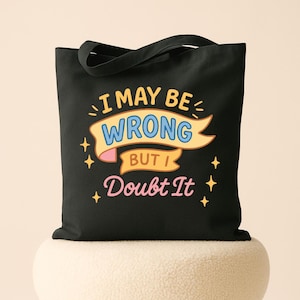 May include: Black tote bag with the text "I MAY BE WRONG BUT I Doubt It" in a colorful design. The text is in a mix of fonts and colors, with a yellow banner and pink accents. The bag has a simple, classic design.