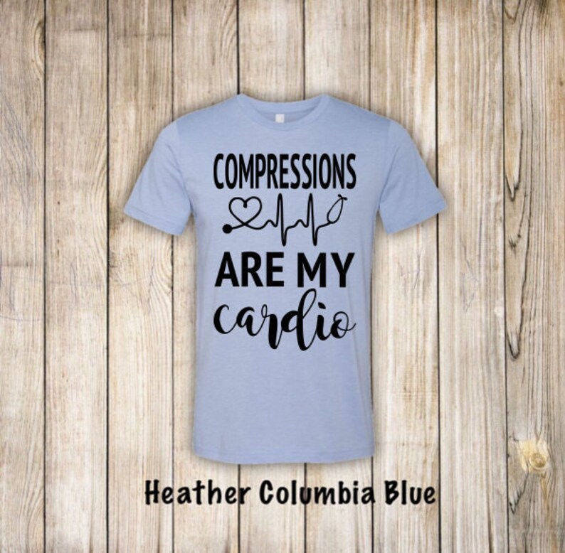 May include: Light blue t-shirt with black text that reads "COMPRESSIONS ARE MY cardio" with a heart and EKG graphic.