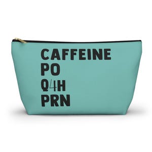 May include: A teal cosmetic bag with a gold zipper and black text that reads "CAFFEINE PO Q4H PRN". The bag is rectangular and has a flat bottom.