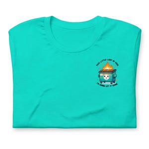 Puede incluir: Una camiseta turquesa con un gr&aacute;fico de un contenedor de basura verde en llamas con el texto "This little light of mine, I'm gonna let it shine."