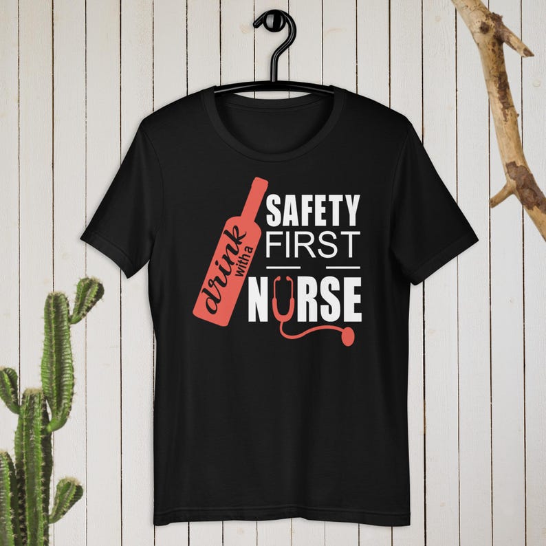 K&ouml;nnte beinhalten: Schwarzes T-Shirt mit einer roten Weinflasche und dem Text "drink with a nurse" und "safety first" in Wei&szlig;.